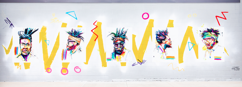 Crowned Series mural by Chrystal Seawood, five colorful portraits of Black men with bold yellow zigzags on a white brick wall